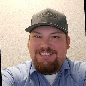 man taking a selfie with brown hat and blue shirt