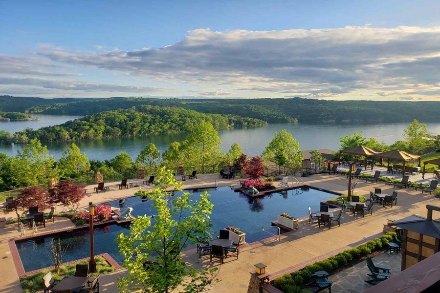 pool alongside a lake with mountains in the back