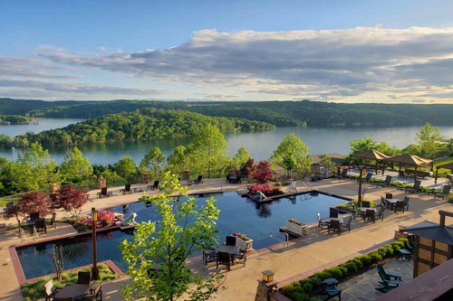 pool alongside a lake with mountains in the back