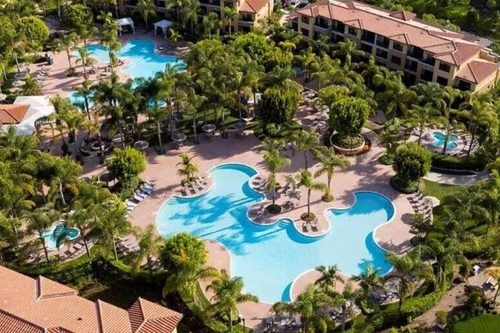 hotel complex with pool and trees.