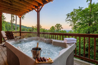 hot tub on a porch with snacks and a view of mountains